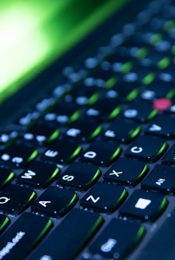 Frame 38 Close-up of backlit gaming laptop keyboard with green accents and red TrackPoint